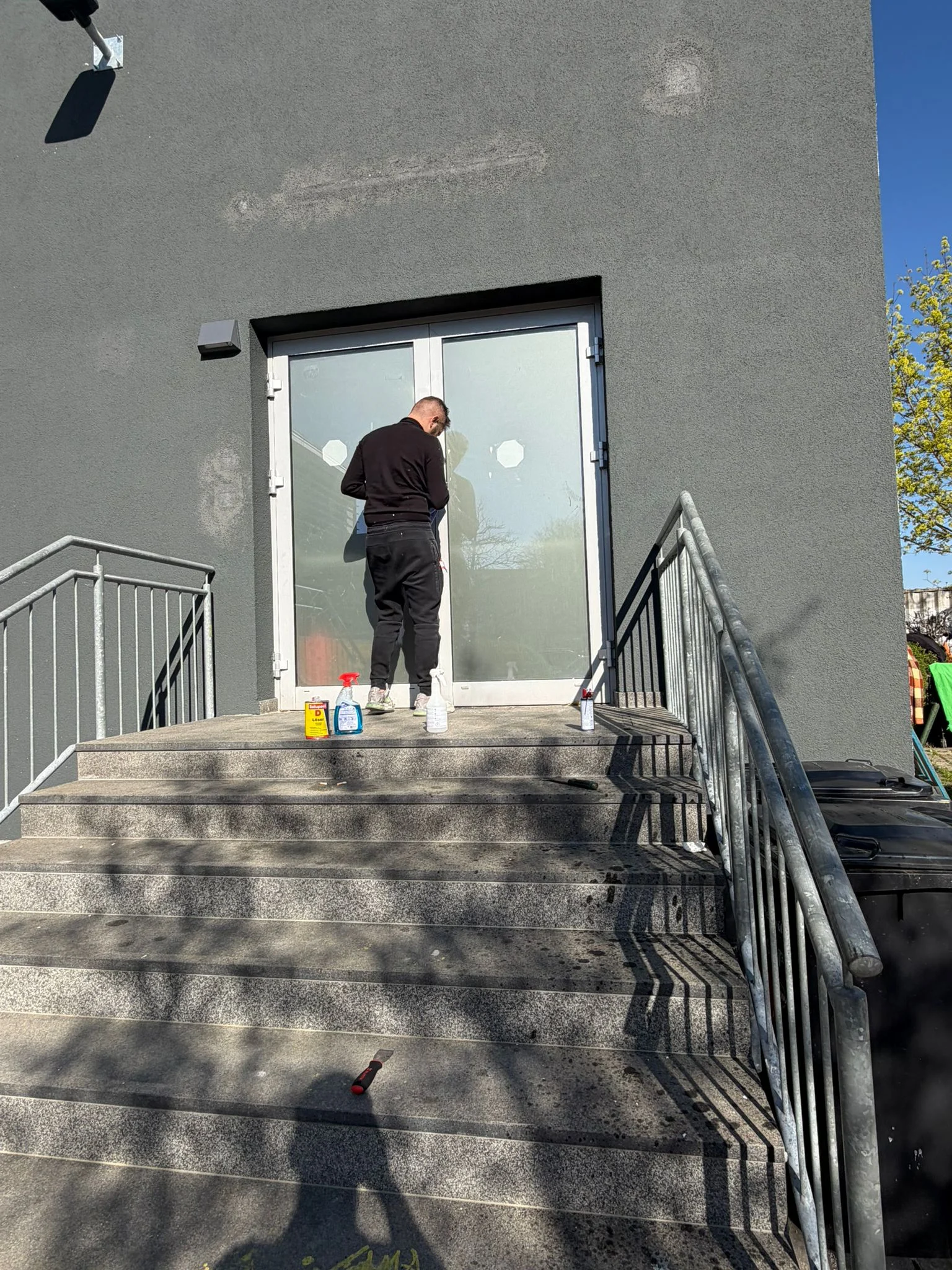 Glasreinigung von einer Eingangstür zum Einkaufszentrum